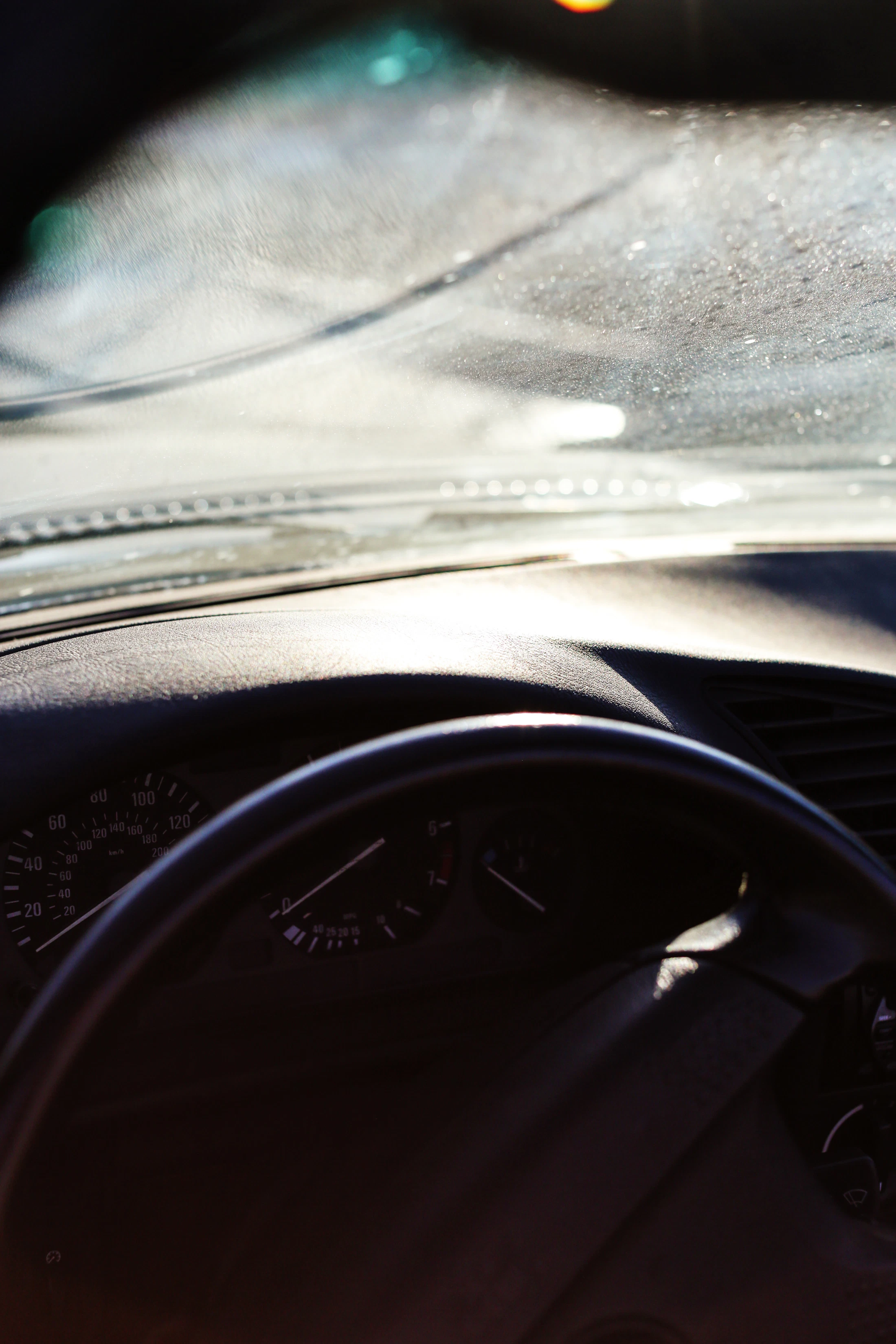 Steering wheel and dashboard of a car in warm sunlight